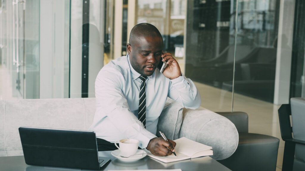 Man on phone taking notes at desk