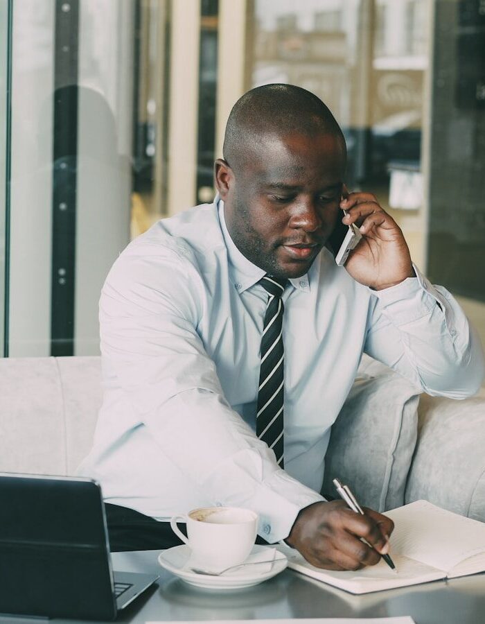 Man on phone taking notes at desk